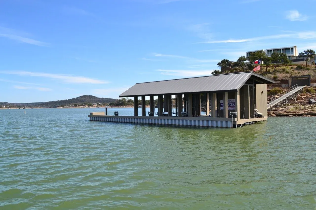 Enclosed floating boathouse with a standing-seam metal roof on open water