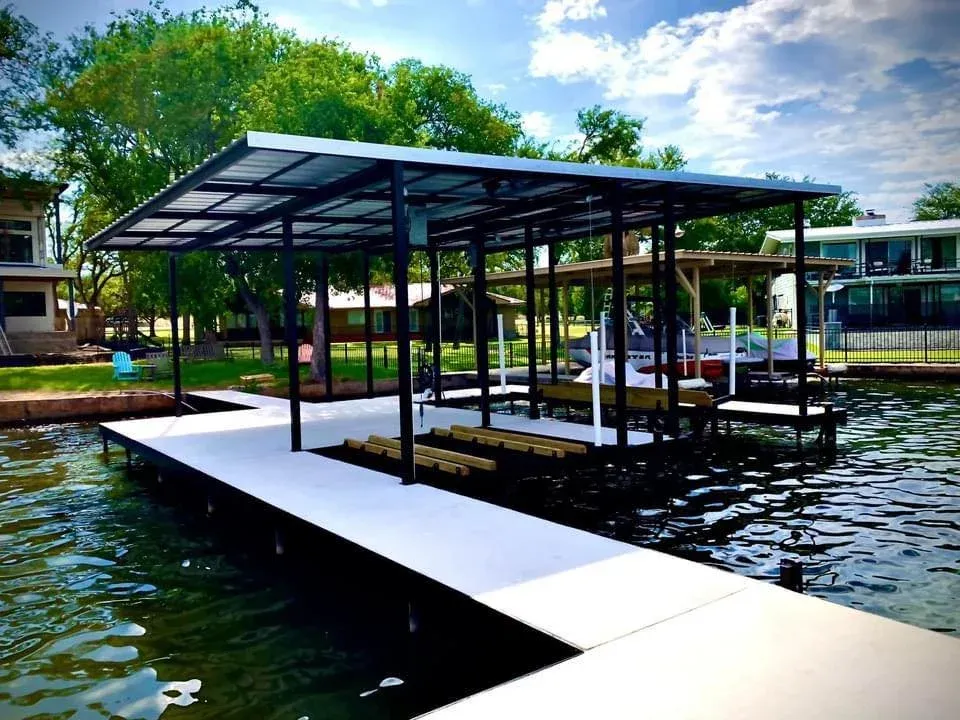 Long concrete dock walkway leading to a covered boat slip under trees